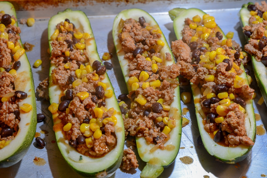 zucchini boats on a baking sheet with filling