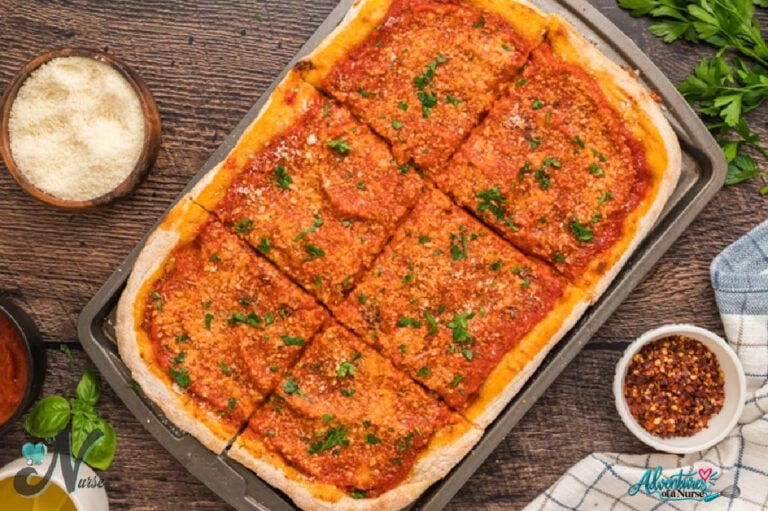 Homemade Utica Tomato Pie cut into rectangular slices, topped with thick tomato sauce, grated cheese, and fresh parsley on a baking sheet.