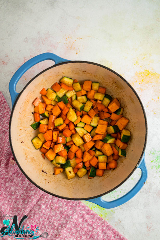 Diced sweet potatoes, carrots, and zucchini saut&eacute;ing in a Dutch oven until softened.