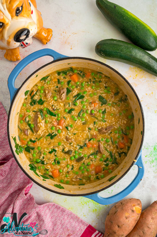 Homemade lamb dog food with brown rice, peas, carrots, and spinach cooked until thick and tender.